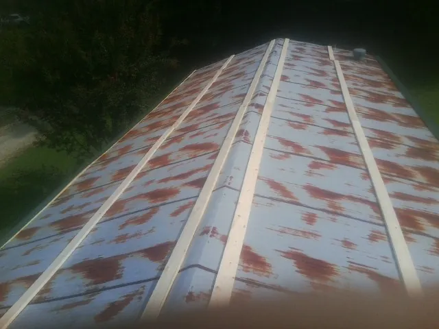 Rusted metal roof panels with new wood purlins before replacement — Storm Damage Roof Repair in Sabina by Roofing Brothers